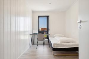 a bedroom with a bed and a desk with a chair at Moderne hus midt i Lofoten in Ballstad