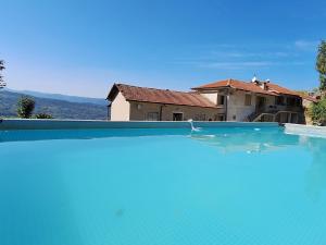 a large blue swimming pool in front of a house at La Cuccia del Sole Panoramische appartementen met zwembad in Cortemilia