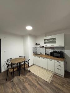 a kitchen with a table and chairs and a microwave at Apartman Ljiljan in Sanski most