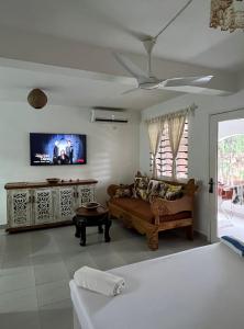 a living room with a couch and a flat screen tv at Studio Leliya 2 in Malindi