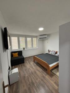 a bedroom with a bed and a couch in it at Apartman Ljiljan in Sanski most