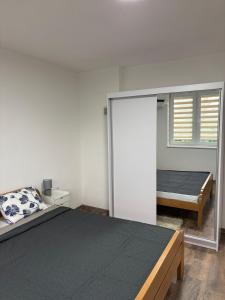 a bedroom with a large bed and a window at Apartman Ljiljan in Sanski most