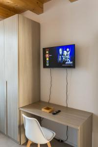 ein Zimmer mit einem Schreibtisch und einem Fernseher an der Wand in der Unterkunft Dimora Caprera - Appartamenti in Falconara Marittima