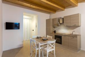 eine Küche mit Tisch und Stühlen in einem Zimmer in der Unterkunft Dimora Caprera - Appartamenti in Falconara Marittima