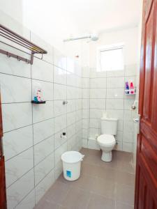a white bathroom with a toilet and a window at Kenya coast stays in Nyali +5 photos