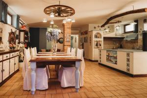 a dining room with a table and a kitchen at Alloggio del Pescatore e Alloggio del Marinaio con Piscina Palestra Jacuzzi Sauna - All Inclusive in Anzio