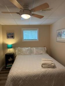 a bedroom with a bed with a ceiling fan at N' This on the Bay -Vacation Suite in Wiarton