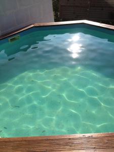 a large pool of blue water in a backyard at les écureuils in Saint-Priest