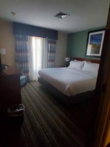 a bedroom with a large white bed and a window at White Pine Lodge in Salamanca