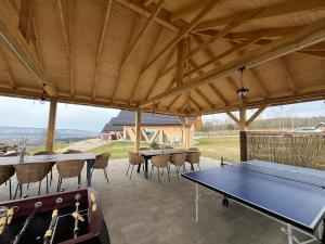 a covered patio with a ping pong table and chairs at 3 Sówki in Krajno Zagórze Drugie