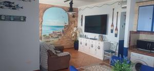 a living room with a painting of the ocean at Alloggio del Pescatore e Alloggio del Marinaio con Piscina Palestra Jacuzzi Sauna - All Inclusive in Anzio