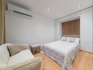 a white bedroom with a bed and a couch at Apartmán Daniel in Levoča