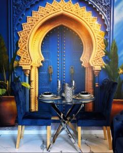 a dining room with a table and blue walls at Suite Riad Luxe avec jacuzzi proche Disney in Nanteuil-lès-Meaux