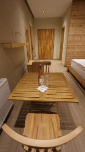 a wooden table with a bottle of wine on it at Perla e Tomorrit EZ in Ujanik