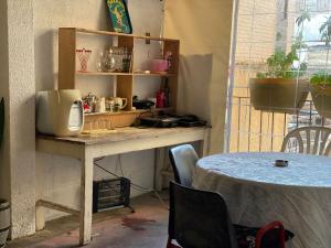 a kitchen with a table and a counter top with a table and a tableablish at Rooms next to Florentine with bomb shelter inside the building in Tel Aviv