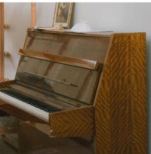 an old piano is sitting in a room at Rooms next to Florentine with bomb shelter inside the building in Tel Aviv +10 photos
