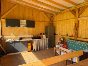 a kitchen with wooden walls and wooden flooring at Glamping - Casuta Zen Fiad in Romuli