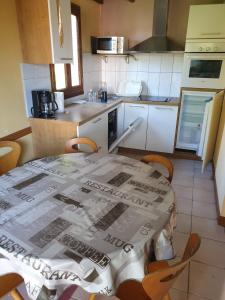 a kitchen with a table with a table cloth on it at Le break vert in Lacapelle-Viescamp