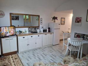 a kitchen with white cabinets and a white refrigerator at Ultracentral STUDIO Koket in Arad