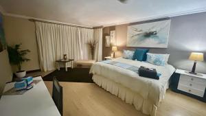 a hotel room with a large bed with blue pillows at Artzys Cottage 1km to Olivedale Clinic in Northriding