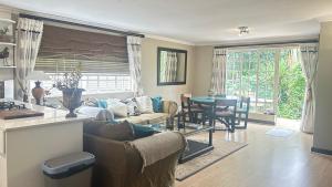 a living room with a couch and a table at Artzys Cottage 1km to Olivedale Clinic in Northriding