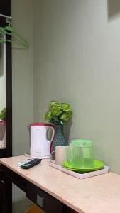 a table with plates and a vase with a plant at Perdana Hotel Labuan in Labuan