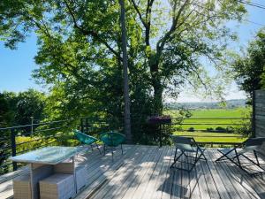 a patio with a table and chairs on a wooden deck at Les Jardins de MaLisa - Adulte Only - in Ferrières-la-Verrerie