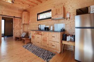 a kitchen with a refrigerator and wooden walls at Recanto Terra Alta in São Roque do Pico +45 photos