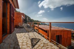 a balcony with two chairs and a view of the ocean at Recanto Terra Alta in São Roque do Pico