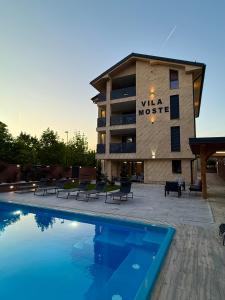 a hotel with a swimming pool in front of a building at Villa Moste Ljubljana - Modern apartments with Pool, EV station & free parking in Ljubljana