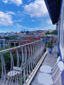 a balcony with white chairs and a view of a city at MyHouse in Da Lat