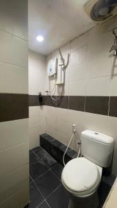 a bathroom with a white toilet in a room at Perdana Hotel Labuan in Labuan +16 photos