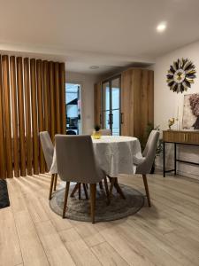 a dining room with a white table and chairs at Mille in Igalo +10 photos