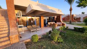 a patio with chairs and tables on a house at Cosy Romantic Sea View Villa at a 5 Hotel in Sharm El Sheikh