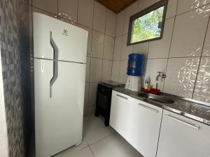 a kitchen with a white refrigerator and a sink at Casa com 2 suítes em Lavras Novas in Ouro Preto