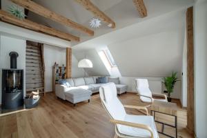 a living room with white furniture and wooden floors at Das Detox Almhaus in Pusterwald