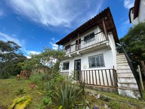 a white house with a wooden fence at Casa com 2 suítes em Lavras Novas in Ouro Preto