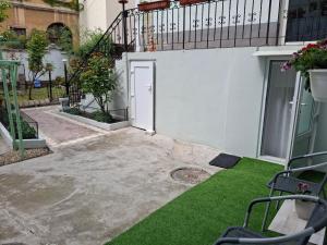 a courtyard with a white door and green grass at Ultracentral STUDIO Koket in Arad