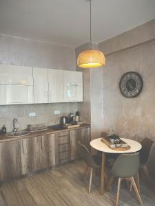 a kitchen with a table and chairs and a clock at Amare&Mare Apartment in Sutomore