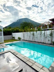 a swimming pool with a mountain in the background at villa Elfame Lokon in Tomohon