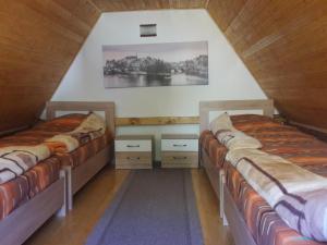 a room with two beds in a attic at Vikendica Ivanović in Prisoja