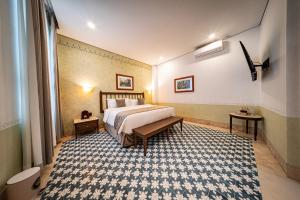 a hotel room with a bed and a rug at Hotel Emperador Orizaba in Orizaba