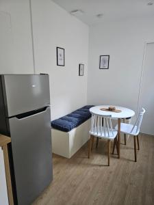 a kitchen with a table and a bed and a table and chairs at L'Écrin Manceau Élégance, Sérénité & Confort in Le Mans