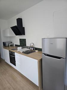a kitchen with a stainless steel refrigerator and a sink at L'Écrin Manceau Élégance, Sérénité & Confort in Le Mans +5 photos