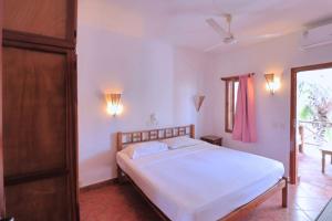 a bedroom with a white bed and a window at Watamu Ascot Residence in Watamu +48 photos