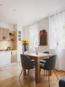 a kitchen and dining room with a wooden table and chairs at Little Vine House in Mostar