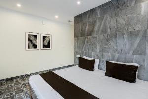 a bedroom with a large bed with a stone wall at Hotel O Dream Vegas in Hyderabad +21 photos