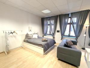 a bedroom with a bed and a couch at Grosses Zimmer im Zentrum Elise , ruhig & gemuetlich in Chemnitz
