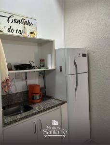 a small kitchen with a refrigerator and a sink at SUITES SANTA FÉcg A5 in Campo Grande +3 photos