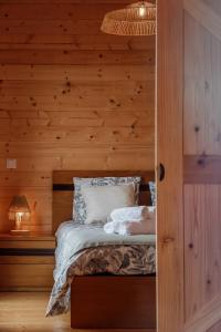 a bedroom with a bed with a wooden wall at Recanto Terra Alta in São Roque do Pico